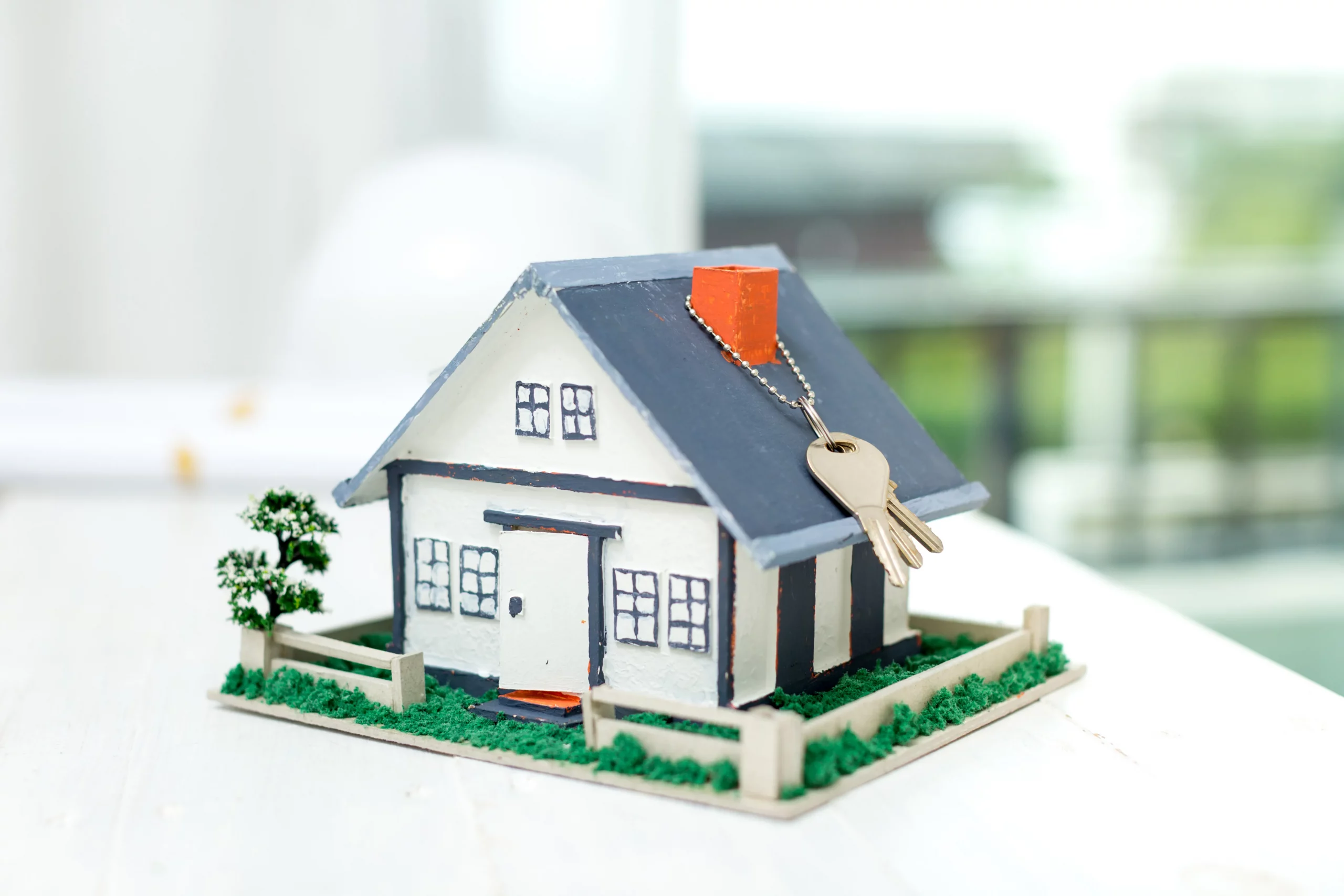 Real estate concept with house model and keys on a table
